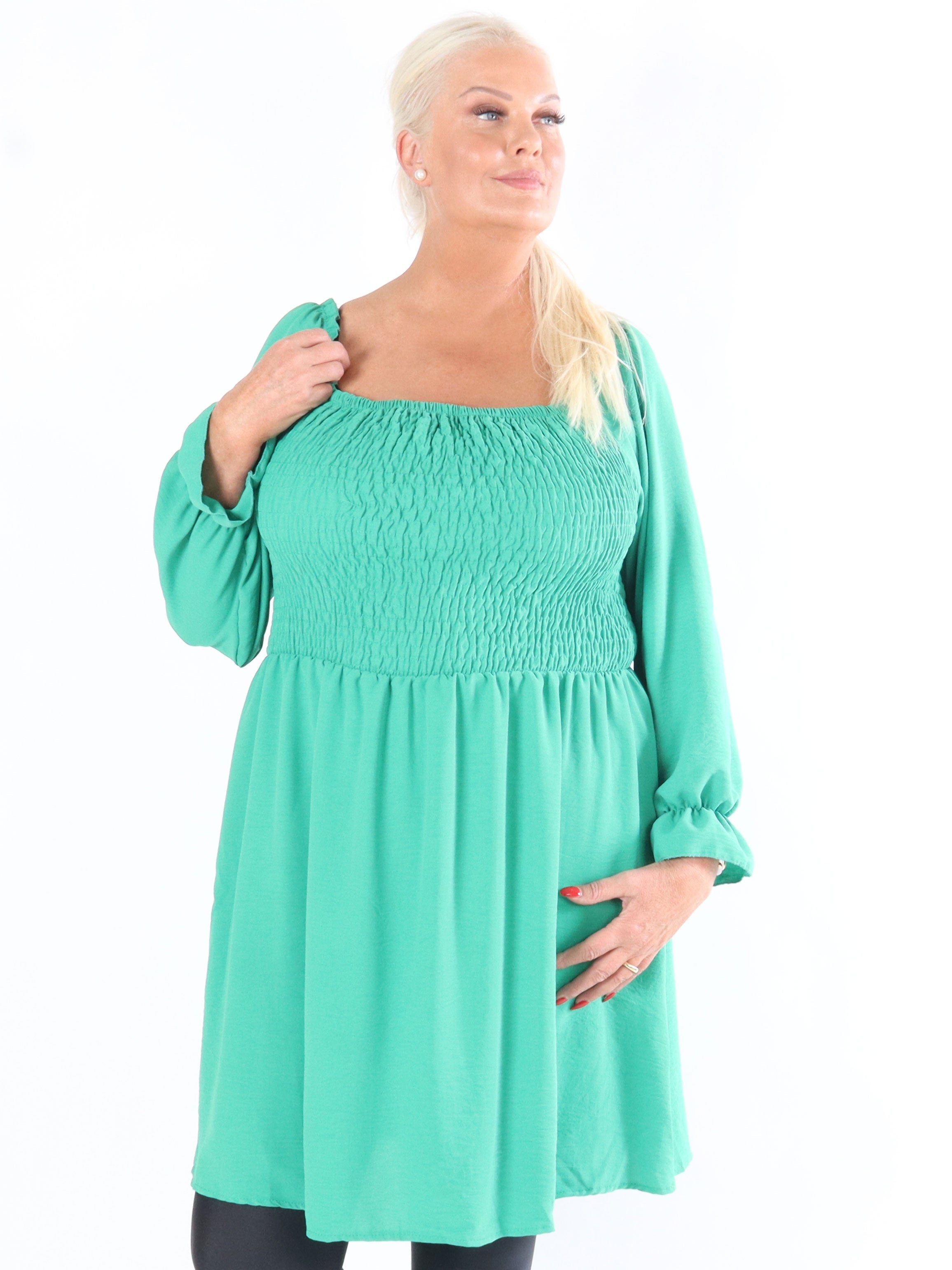 Nukaka - Armégrön klänning med långa ärmar och en kavaj över bröstet.